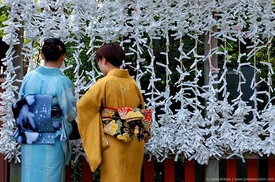 Chicas colocando su omikuji de mala suerte en un árbol